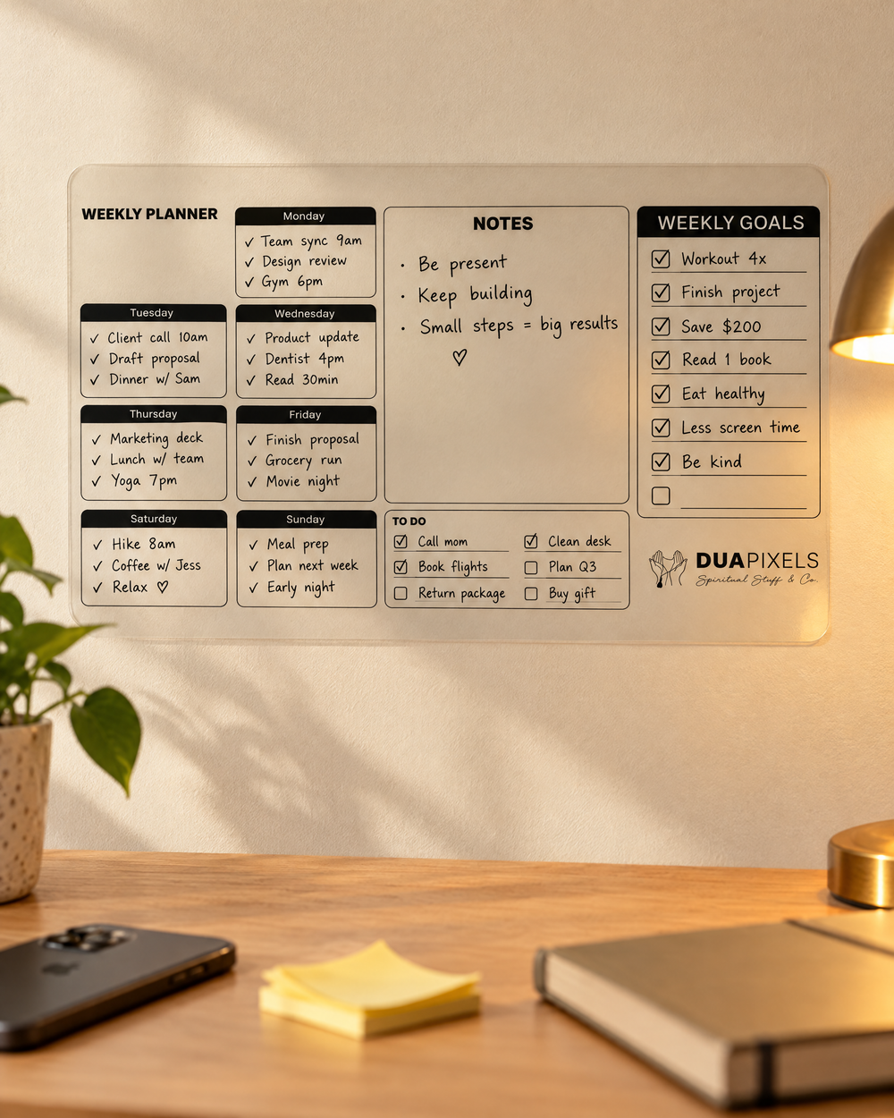 Phone face down, sticky notes and a diary in front of the wall planner